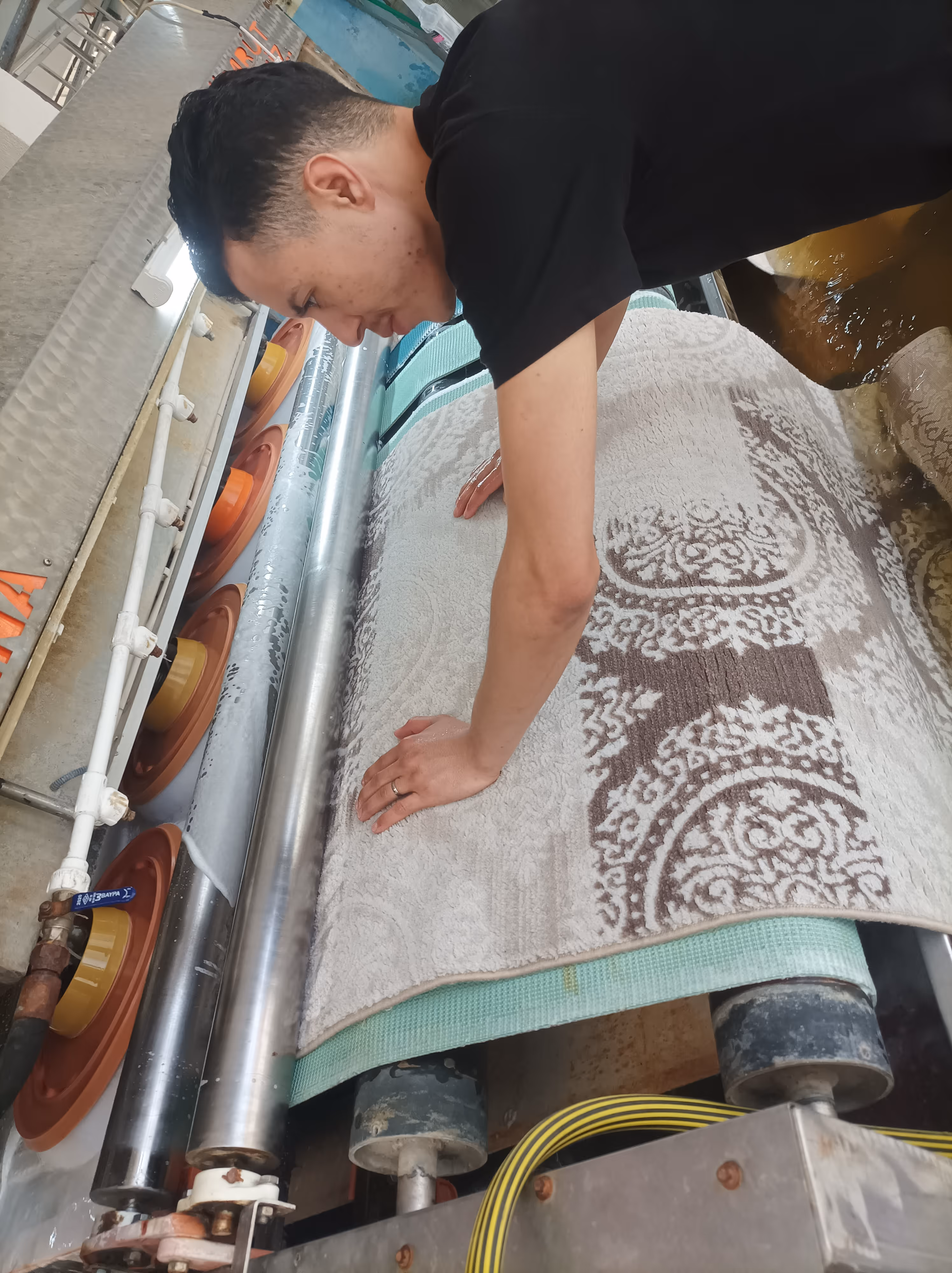 Usta halıyı makinede yıkarken